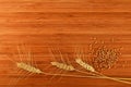 Wooden bamboo cutting board with three wheat ears and grains